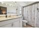 Bathroom featuring a white vanity with a marble countertop and shower with floral curtains at 1111 Lakemont Dr, Valrico, FL 33594