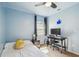 Bedroom features blue walls, carpet, a ceiling fan, desk, and a window at 1111 Lakemont Dr, Valrico, FL 33594