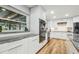Modern kitchen with white cabinets, stainless steel appliances, gray countertops, and wood flooring at 1111 Lakemont Dr, Valrico, FL 33594