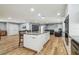 Spacious kitchen island with white cabinetry, granite countertops, wood floors, and an open living area at 1111 Lakemont Dr, Valrico, FL 33594