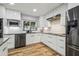 Contemporary kitchen featuring white cabinets, stainless steel appliances, granite countertops, and wood floors at 1111 Lakemont Dr, Valrico, FL 33594