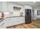 Modern kitchen featuring white cabinets, granite countertops, stainless steel appliances, and wood flooring at 1111 Lakemont Dr, Valrico, FL 33594
