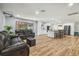 Open-concept living room with reclining sofas, wood floors, and modern kitchen with an island at 1111 Lakemont Dr, Valrico, FL 33594