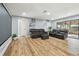 Open concept living room featuring wood floors, projector screen, and a reclining sofa set at 1111 Lakemont Dr, Valrico, FL 33594