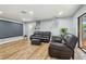 Spacious living room featuring wood floors, projector screen, and a reclining sofa set at 1111 Lakemont Dr, Valrico, FL 33594