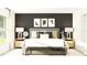 Staged bedroom with a black accent wall, plush bed, lamps and stylish decor at 11817 Blue Diamond Trl, Parrish, FL 34219