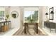 Airy dining room with a wooden table, woven chairs, modern lighting, and outdoor view at 11844 Blue Diamond Trl, Parrish, FL 34219