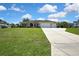 Exterior of the home, featuring a well-manicured lawn and an extra-long driveway at 12012 Cromwell Way, Spring Hill, FL 34609