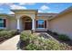 Charming home featuring an arched entry, decorative shutters, and attractive landscaping at 12012 Cromwell Way, Spring Hill, FL 34609