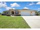 Beautifully landscaped single-story home with a three car garage and a well-manicured front lawn at 12012 Cromwell Way, Spring Hill, FL 34609