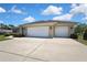 Spacious three-car garage with well-maintained driveway and exterior lighting at 12012 Cromwell Way, Spring Hill, FL 34609