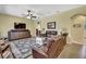 Comfortable living room with leather furniture, patterned rug, ceiling fan, and neutral colored walls at 12012 Cromwell Way, Spring Hill, FL 34609