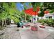 Inviting backyard with lush greenery, an orange patio umbrella, and outdoor seating area perfect for entertaining at 1210 Bay Palm Blvd, Indian Rocks Beach, FL 33785