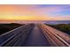 Picturesque sunset view of a boardwalk leading to the beach and calm ocean waters at 1210 Bay Palm Blvd, Indian Rocks Beach, FL 33785