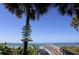 Scenic beach access with a 'leave nothing but your footprints' sign, palm trees, and ocean view at 1210 Bay Palm Blvd, Indian Rocks Beach, FL 33785