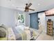 Stylish bedroom with a sliding barn door, ceiling fan, and a view to the green outdoors at 1210 Bay Palm Blvd, Indian Rocks Beach, FL 33785