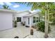 Charming beach house with tropical landscaping, light purple paint, and welcoming entrance at 1210 Bay Palm Blvd, Indian Rocks Beach, FL 33785