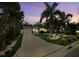 Beautiful home exterior featuring a long driveway, tropical landscaping, and a glimpse of the house at 1210 Bay Palm Blvd, Indian Rocks Beach, FL 33785
