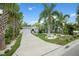 Charming single-story home with tropical landscaping and a spacious driveway leading to an attached garage at 1210 Bay Palm Blvd, Indian Rocks Beach, FL 33785