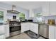 Well-equipped kitchen featuring stainless steel appliances, white cabinetry, and a view of the patio at 1210 Bay Palm Blvd, Indian Rocks Beach, FL 33785
