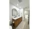 Bright bathroom with double sinks and stylish black framed, arched mirrors at 12334 Country White Cir, Tampa, FL 33635