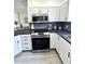 Bright kitchen features stainless steel appliances, modern cabinetry and black countertops at 12334 Country White Cir, Tampa, FL 33635