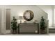 Inviting entryway with console table, decorative mirror, potted plants, and an open doorway at 13147 Empress Jewel Trl, Parrish, FL 34219