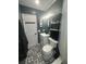 Stylish bathroom featuring black and white patterned floors, white vanity, and black accents at 1459 Joel Ln, Clearwater, FL 33755
