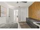 Bright bedroom featuring wood accent wall, gray dresser, and view of a hallway at 1459 Joel Ln, Clearwater, FL 33755