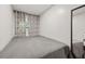 Simple bedroom with a gray bedspread, window with patterned curtains, and full-length mirror at 1459 Joel Ln, Clearwater, FL 33755