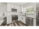 Bright modern kitchen featuring stainless steel appliances, white cabinets and countertops at 1459 Joel Ln, Clearwater, FL 33755