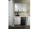 Modern kitchenette featuring white cabinets, a sleek black sink, and a compact refrigerator at 1459 Joel Ln, Clearwater, FL 33755