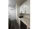 Efficient kitchenette with white cabinets, a black sink, granite countertop, and compact refrigerator at 1459 Joel Ln, Clearwater, FL 33755