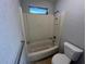 Standard tub and shower stall with white textured walls and small window above at 14725 Morning Dr, Lutz, FL 33559