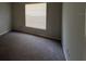 Bedroom with neutral carpet, window and a wall outlet visible in the corner of the room at 14725 Morning Dr, Lutz, FL 33559