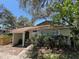 Charming single-story home featuring mature trees, lush landscaping and a covered front entryway at 14725 Morning Dr, Lutz, FL 33559