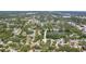 A high angle view of a neighborhood surrounded by mature trees and a small pond at 1516 Santa Anna Dr, Dunedin, FL 34698