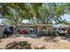 A serene backyard featuring a patio, perfect for outdoor living, complemented by shade trees and a privacy fence at 1516 Santa Anna Dr, Dunedin, FL 34698