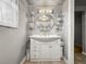 Bathroom vanity area with a round mirror, shelving, and a decorative light fixture at 1516 Santa Anna Dr, Dunedin, FL 34698