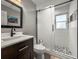 Bathroom featuring a dark vanity cabinet, toilet, and glass enclosed shower with mosaic tile flooring at 1516 Santa Anna Dr, Dunedin, FL 34698