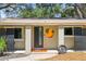 Charming front exterior with a unique art piece and modern door at 1516 Santa Anna Dr, Dunedin, FL 34698