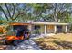Charming single-story home with an orange golf cart in the driveway at 1516 Santa Anna Dr, Dunedin, FL 34698