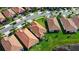 Aerial view of homes with red tile roofs and green lawns with nearby ponds at 16913 Anchor Root St, Wimauma, FL 33598