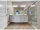 Elegant bathroom features a double vanity, large mirror, and modern glass enclosed shower at 16913 Anchor Root St, Wimauma, FL 33598