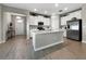Open-concept kitchen featuring white cabinets, an island with quartz countertops, and stainless steel appliances at 16913 Anchor Root St, Wimauma, FL 33598