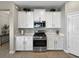 Modern kitchen with white cabinets, stainless steel appliances, and light countertops with decorative plants at 16913 Anchor Root St, Wimauma, FL 33598