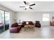Bright living room features wood floors, fan, and comfortable seating, perfect for relaxing or entertaining guests at 16913 Anchor Root St, Wimauma, FL 33598
