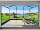 View from screened in patio out to pond and green lawn with neighborhood homes beyond at 16913 Anchor Root St, Wimauma, FL 33598