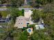 Aerial view of the house with a pool, driveway, and surrounding mature trees at 1799 Dixie Hwy, Tarpon Springs, FL 34689