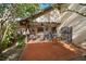 Back patio with outdoor seating, ceiling fan, lush tropical plants, and barbeque at 1799 Dixie Hwy, Tarpon Springs, FL 34689